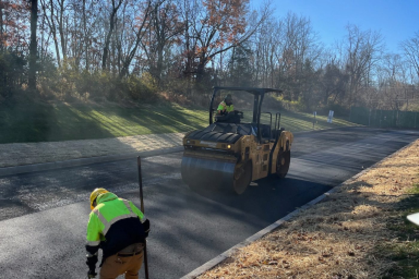 Vibratory roller compacting a fresh asphalt mat on a commercial road in NJ