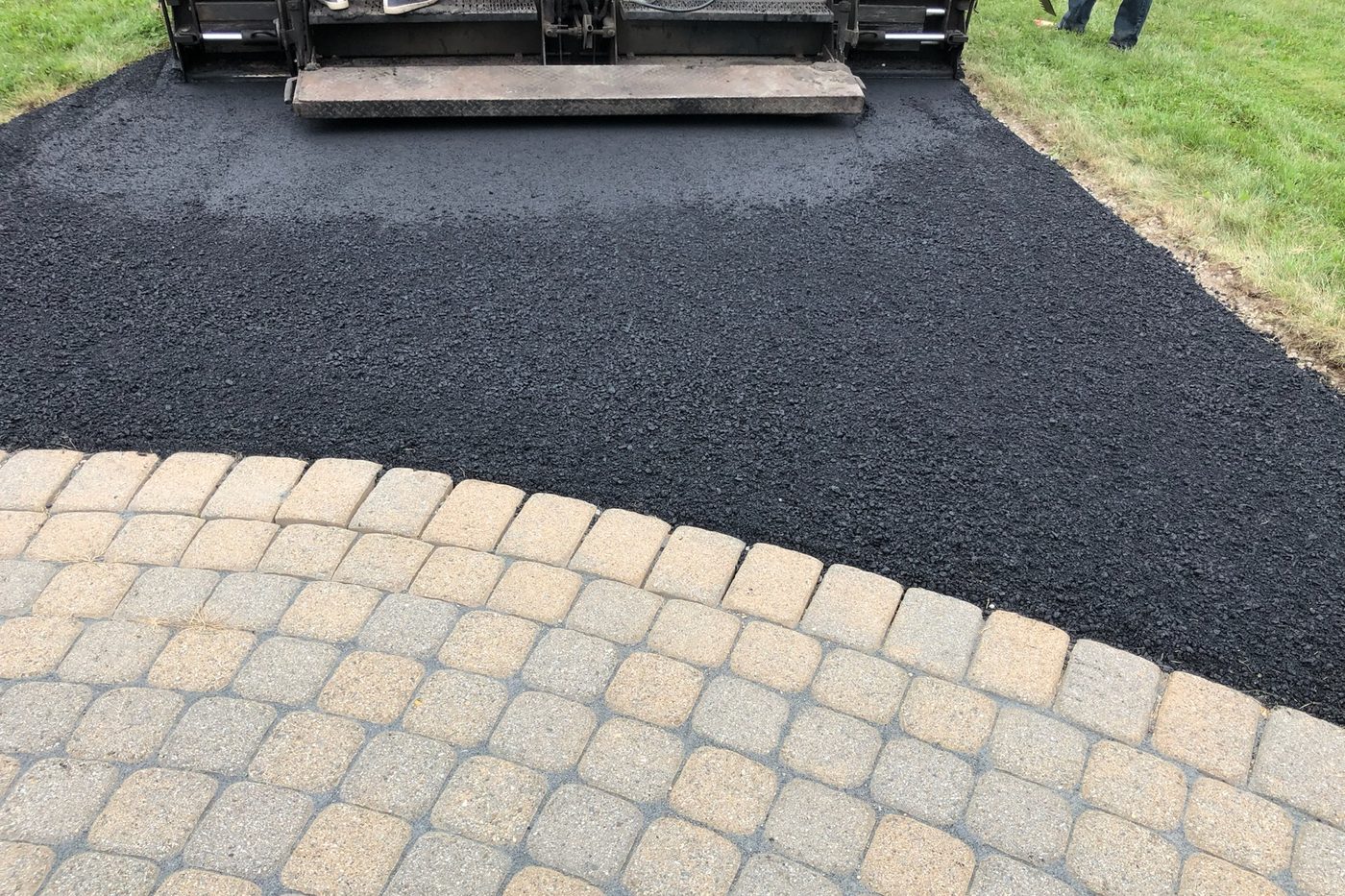 Fresh asphalt laid up to a decorative paver-block apron on a residential driveway in NJ