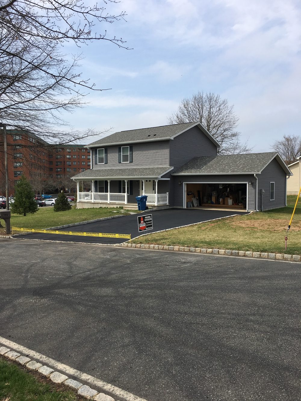 Newly paved residential driveway cordoned off to cure, with a Beckage Paving Division yard sign in NJ