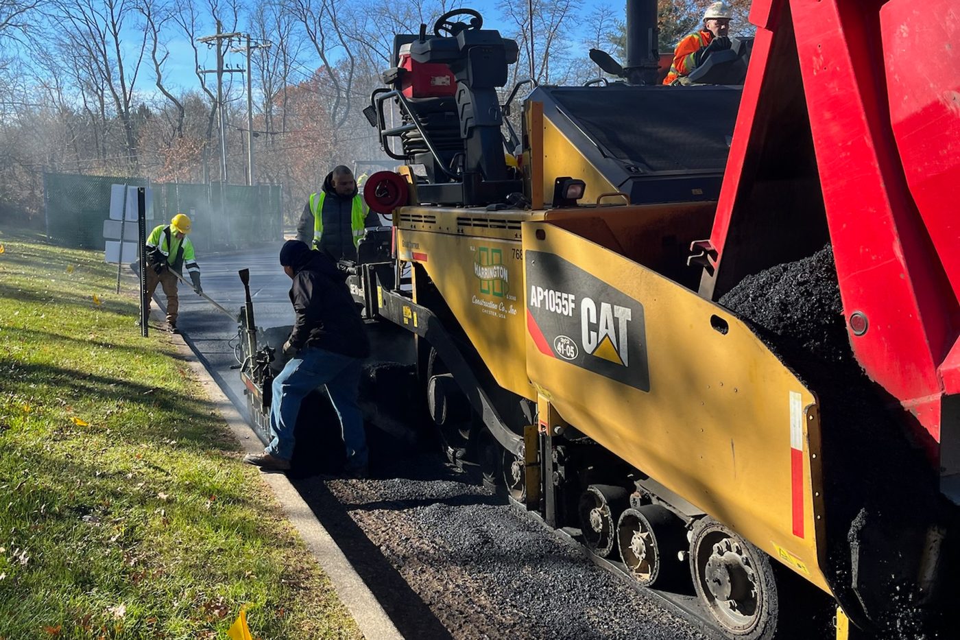 Beckage crew laying a fresh asphalt wearing course behind a Caterpillar paver on a commercial resurfacing job in NJ