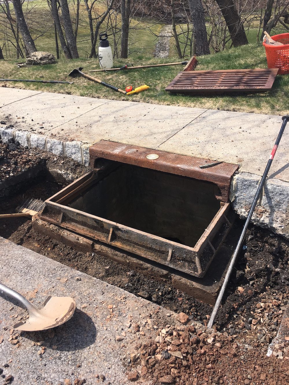Excavated storm drain with the cast iron casting lifted out and the surrounding asphalt cut away, by Beckage in NJ